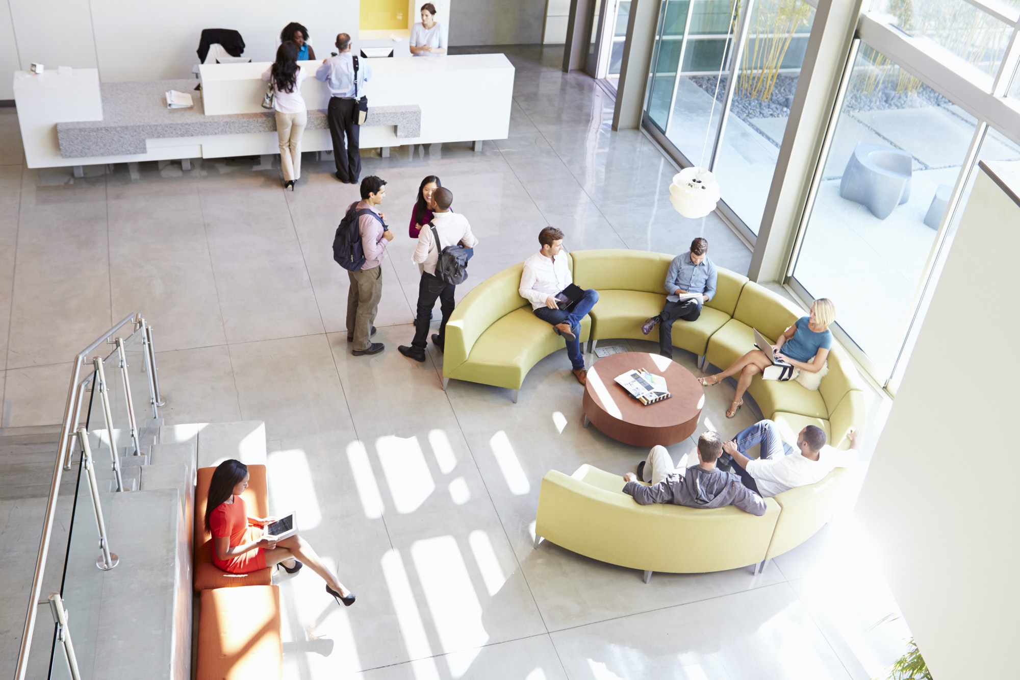 Reception Area Of Modern Office Building With People